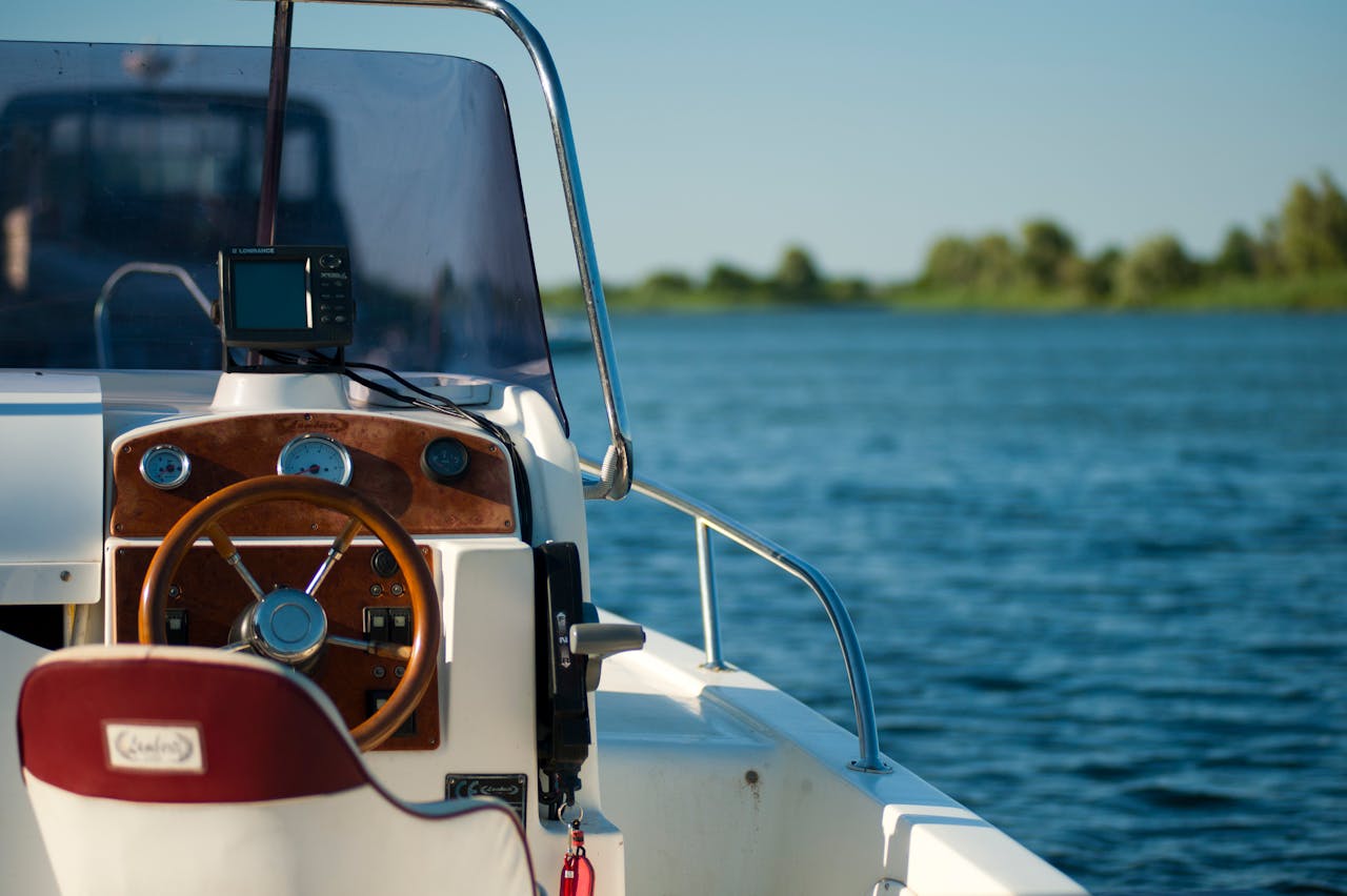 home-hero A yacht steering wheel with a serene water view during a bright summer day offering leisure and adventure.